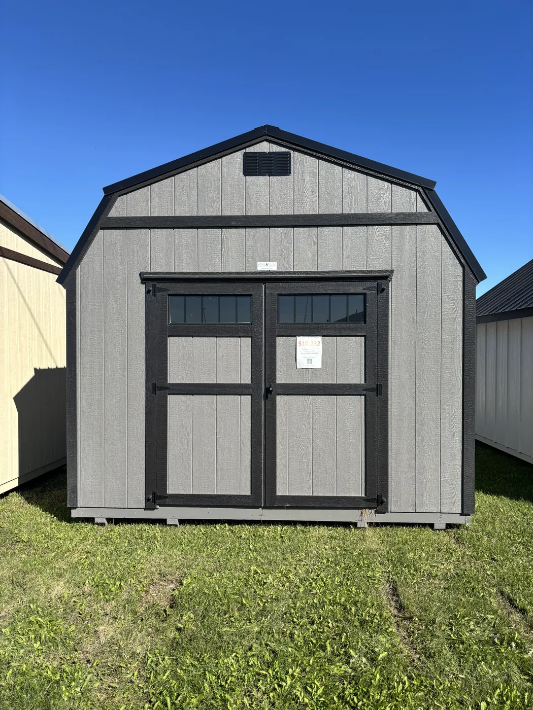 Grey lofted barn shed with black double doors at Borderland Powersports, Portage la Prairie MB